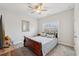 Neutral bedroom featuring a ceiling fan and a mirror hung above a cozy queen-size bed with a wooden frame at 115 Harlow Cir, Roswell, GA 30076