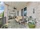 Charming covered patio with brick flooring, comfortable seating, and inviting decor for relaxing outdoors at 115 Harlow Cir, Roswell, GA 30076