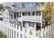 Two-story home with white picket fence, bay window, balcony and view of surrounding trees at 1606 Vicksburg Pl, Atlanta, GA 30350