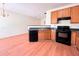 Functional kitchen featuring standard appliances, wood cabinetry, and a breakfast bar at 290 Brookview Dr, Riverdale, GA 30274