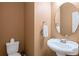 Powder room features an oval mirror, pedestal sink, and a crisp white hand towel at 453 Clematis Ct, Temple, GA 30179