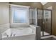 Bright bathroom featuring a large window, tub, and separate shower at 453 Clematis Ct, Temple, GA 30179
