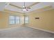Spacious bedroom featuring a tray ceiling, ceiling fan, and two windows at 453 Clematis Ct, Temple, GA 30179