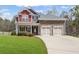 Charming two-story home featuring a manicured lawn, brick accents, and a two-car garage, all under a sunny sky at 453 Clematis Ct, Temple, GA 30179