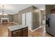 Open-concept kitchen with island flows into a cozy living room featuring a stone fireplace and hardwood floors at 453 Clematis Ct, Temple, GA 30179