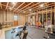 Unfinished basement featuring exposed beams and ductwork, workout equipment, and door at 6695 Woodstock Rd, Acworth, GA 30102