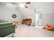 Bright bedroom with sloped ceilings, a crib, rocking chair, and neutral decor at 6695 Woodstock Rd, Acworth, GA 30102