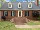 Inviting brick facade with multi-tiered steps leading to front door; dormer windows add curb appeal at 6695 Woodstock Rd, Acworth, GA 30102