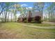 Well-maintained front yard with lush green lawn and a charming brick home at 6695 Woodstock Rd, Acworth, GA 30102