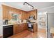 Well-lit kitchen with wooden cabinets, granite countertops, stainless steel appliances, and hardwood floors at 6695 Woodstock Rd, Acworth, GA 30102