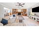 Bright, open living room with stone fireplace, built-in shelving, large sofa, and ample natural light at 6695 Woodstock Rd, Acworth, GA 30102