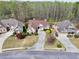 Aerial view showcasing three houses, driveways, manicured lawns, and mature trees surrounding the properties at 2323 Council Ln, Buford, GA 30519