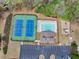 Aerial view featuring tennis courts, swimming pool, playground, and parking lot near lush trees at 2323 Council Ln, Buford, GA 30519