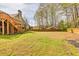 Backyard showcasing deck and spacious lawn with mature trees, providing ample outdoor living and entertainment space at 2323 Council Ln, Buford, GA 30519