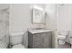 Bathroom featuring a marble tiled shower, toilet, and vanity with storage at 554 Mcgill Ne Pl, Atlanta, GA 30312