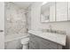 Bathroom featuring a marble tiled shower and vanity with updated fixtures at 554 Mcgill Ne Pl, Atlanta, GA 30312