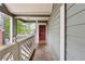 Cozy front porch with wooden floors and painted railings leading to a red front door at 554 Mcgill Ne Pl, Atlanta, GA 30312