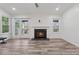Bright living room with hardwood floors, fireplace, ceiling fan, and a sliding glass door to the outside at 554 Mcgill Ne Pl, Atlanta, GA 30312