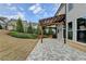 Backyard view showcasing the hardscaped patio, landscaping, and dark metal fence at 6585 Creekview Cir, Duluth, GA 30097