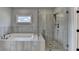 A luxurious bathroom features a tub and shower with glass door at 6585 Creekview Cir, Duluth, GA 30097