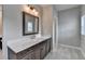 Bathroom features a vanity with quartz countertop, wood frame mirror, and tile flooring at 6585 Creekview Cir, Duluth, GA 30097
