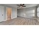 Bedroom features hardwood floors, ceiling fan, one window with plantation shutters, and attached bathroom at 6585 Creekview Cir, Duluth, GA 30097