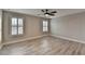 This bedroom features hardwood floors, a ceiling fan, and two windows with plantation shutters at 6585 Creekview Cir, Duluth, GA 30097