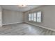 Bright bedroom featuring gray wood flooring, neutral walls, and shuttered windows at 6585 Creekview Cir, Duluth, GA 30097