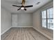 This bedroom features hardwood floors, a ceiling fan, and a window with plantation shutters at 6585 Creekview Cir, Duluth, GA 30097