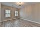 Well-lit bedroom with gray wood flooring, neutral walls, shuttered windows, and ceiling fan at 6585 Creekview Cir, Duluth, GA 30097