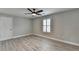 Cozy bedroom featuring wood flooring, neutral walls, ceiling fan, and a shuttered window at 6585 Creekview Cir, Duluth, GA 30097