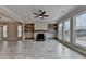 Spacious living room featuring fireplace, built-in shelving, large windows and gray wood flooring at 6585 Creekview Cir, Duluth, GA 30097