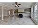 Open-concept living room featuring large windows, fireplace, built-in shelves, and stylish ceiling fan at 6585 Creekview Cir, Duluth, GA 30097