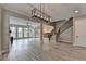 Bright, open living room with wood-look flooring, modern chandelier, and view of the kitchen and backyard at 6585 Creekview Cir, Duluth, GA 30097