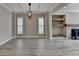 Open-concept living area featuring a modern chandelier, large windows, and a cozy fireplace at 6585 Creekview Cir, Duluth, GA 30097