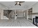 Open living room with fireplace, built-in shelving, and hardwood floors with staircase nearby at 6585 Creekview Cir, Duluth, GA 30097