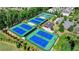 Aerial view of multiple tennis courts and a small pavilion surrounded by trees in the community at 6585 Creekview Cir, Duluth, GA 30097