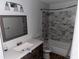 A modern bathroom featuring a vanity with a mirror and a shower with patterned tile at 6921 Babbling Brook Dr, Rex, GA 30273