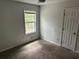 A cozy bedroom featuring neutral tones, natural light from the window, and carpet flooring at 6921 Babbling Brook Dr, Rex, GA 30273