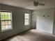 A bedroom with two windows offering ample natural light, a ceiling fan, and neutral decor at 6921 Babbling Brook Dr, Rex, GA 30273