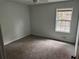 Cozy bedroom with a carpeted floor and a large window overlooking the outdoors at 6921 Babbling Brook Dr, Rex, GA 30273