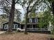 Charming two-story home with a inviting porch, white trim, and beautiful trees at 6921 Babbling Brook Dr, Rex, GA 30273