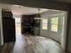 Well-lit kitchen featuring gray cabinets, stainless steel appliances, and durable, stylish wood-look flooring at 6921 Babbling Brook Dr, Rex, GA 30273