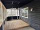 A screened porch with wooden floorboards, a ceiling fan, and an outdoor view at 6921 Babbling Brook Dr, Rex, GA 30273