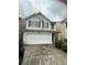 Two-story home featuring a front-facing garage, gray siding, and a neatly maintained front yard at , Covington, GA 30016