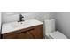 Modern bathroom featuring wood vanity, white sink, and matching low-consumption toilet at 1604 Niskey Lake Sw Rd, Atlanta, GA 30331