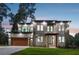 Stunning modern home featuring a balcony, stone accents, and a seamlessly integrated two-car garage at 1604 Niskey Lake Sw Rd, Atlanta, GA 30331