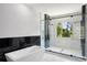 Bathroom featuring a soaking tub and a glass-enclosed shower with black and white tile at 1610 Niskey Lake Sw Rd, Atlanta, GA 30331