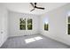 A bright, neutral bedroom is accentuated by natural light from the three windows and a ceiling fan at 1610 Niskey Lake Sw Rd, Atlanta, GA 30331