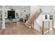 Open-concept living area featuring light wood floors, a staircase, and a sleek fireplace with a modern ceiling fan at 1610 Niskey Lake Sw Rd, Atlanta, GA 30331